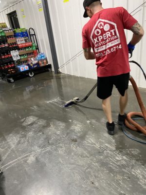Xpert Restoration employee cleaning commercial building that has incurred water damage.